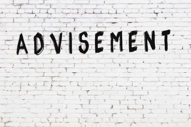 Üzerinde siyah boya ile el yazısı yazılı beyaz tuğla duvar.