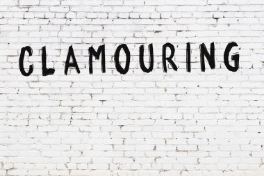 Yazılı beyaz tuğla duvar. Siyah boyayla yazılmış el yazısı.