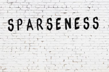 Beyaz tuğlalı duvara siyah boya ile yazılmış bir yazı..