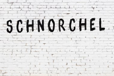 Siyah boyayla el yazısıyla yazılmış beyaz tuğla duvar.