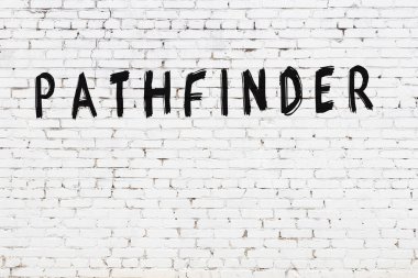 Beyaz tuğla duvarda siyah boya ile yazılmış bir yazıt bulucu..