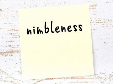 Çeviklik hakkında hatırlatma kavramı. Tahta duvarda üzerinde yazı olan sarı yapışkan kağıt.