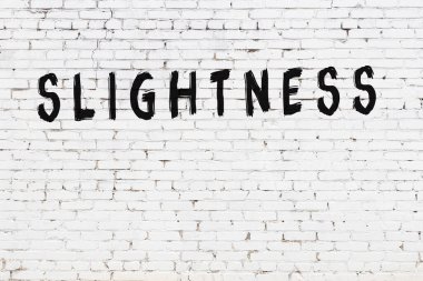 Siyah boyayla yazılmış beyaz tuğlalı bir duvar.