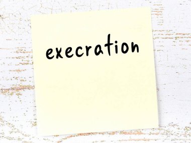 Tahta duvarda el yazısıyla yazılmış sarı yapışkan bir not var.