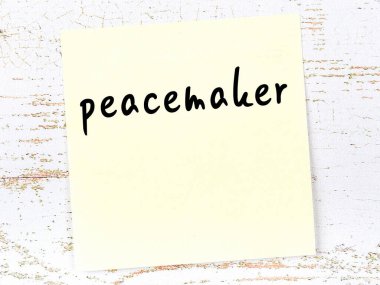 Tahta duvardaki sarı yapışkan notta el yazısıyla yazılmış barış çubuğu var.