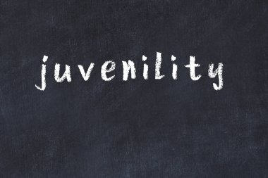 Tebeşir el yazısıyla yazılmış gençlik yazıları siyah masanın üzerinde.