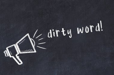 Hoparlörlerin tebeşir çizimi ve siyah masanın üzerine el yazısıyla yazılmış müstehcen kelimeler.