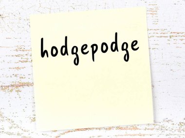 Hodgepodge 'u hatırlatma kavramı. Tahta duvarda üzerinde yazı olan sarı yapışkan kağıt.