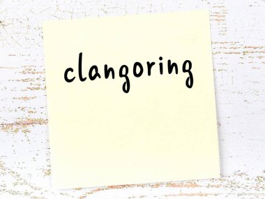 Clangoring hakkında hatırlatma kavramı. Tahta duvarda üzerinde yazı olan sarı yapışkan kağıt.