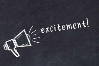 Hoparlörün tebeşir çizimi ve siyah masanın üzerine el yazısıyla yazılmış bir yazı heyecanı.