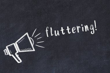 Hoparlör çizimi olan siyah karatahta ve kanat çırpan yazı.