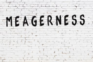 Beyaz tuğlalı duvar, siyah boyayla yazılmış.