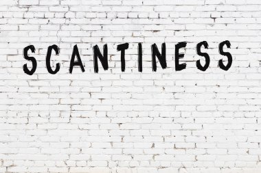 Üzerinde yazı olan beyaz tuğla duvar. Elle yazılmış siyah boya.