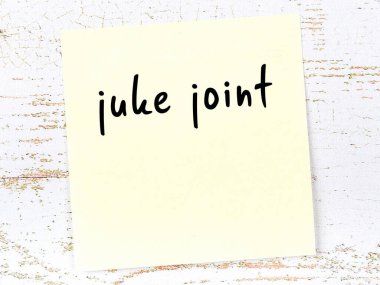 Juke eklemini hatırlatma kavramı. Tahta duvarda üzerinde yazı olan sarı yapışkan kağıt.