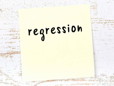 Regresyonu hatırlatma kavramı. Tahta duvarda üzerinde yazı olan sarı yapışkan kağıt.