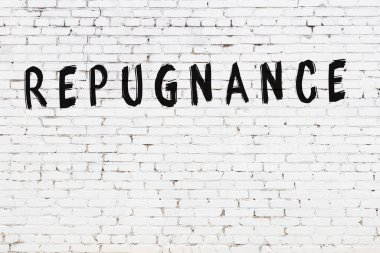 Siyah boyayla yazılmış beyaz tuğlalı bir duvar.