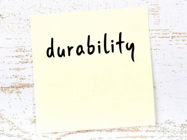 Dayanıklılık kavramı. Tahta duvarda üzerinde yazı olan sarı yapışkan kağıt.