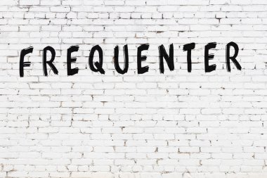 Üzerinde yazı olan beyaz tuğla duvar sık sık siyah boya ile elle yazılmış.