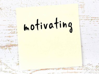 Tahta duvardaki sarı yapışkan notta elle yazılmış yazılar motive edici.