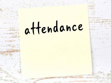 Tahta duvarda el yazısıyla yazılmış sarı yapışkan bir not var.