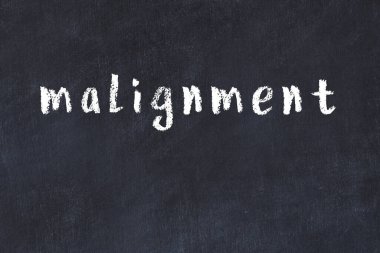 Tebeşir el yazısıyla yazılmış kara masanın üzerine kötü bir yazı.