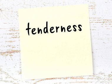 Şefkat hakkında hatırlatma kavramı. Tahta duvarda üzerinde yazı olan sarı yapışkan kağıt.