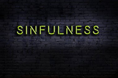 Tuğla duvara karşı işlenmiş günahkar bir neon işareti. Gece görünümü