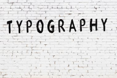 Yazıt tipografisi beyaz tuğla duvara siyah boya ile yazılmış..