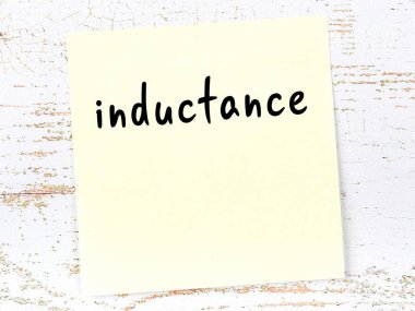 Tahta duvarda el yazısıyla yazılmış sarı yapışkan bir not.