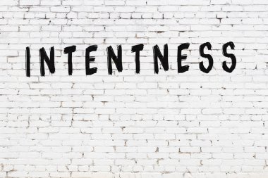 Yazı yoğunluğu beyaz tuğla duvara siyah boya ile yazılmış..