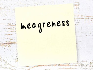 Tahta duvardaki sarı yapışkan notta el yazısıyla yazılmış yetersiz yazılar var.