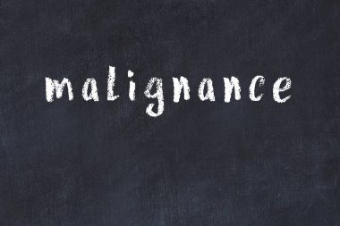 Tebeşir el yazısıyla yazılmış kötü niyet siyah masada.