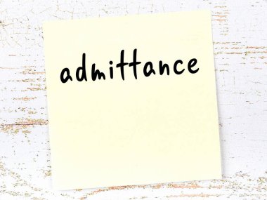 Tahta duvarda el yazısıyla yazılmış sarı yapışkan bir not var.