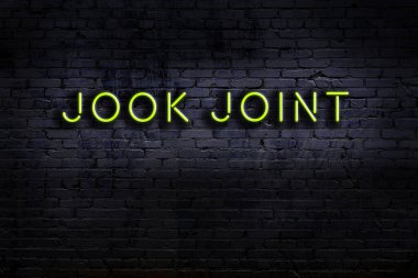 Duvara yazı kazınmış neon levhası. Gece görünümü