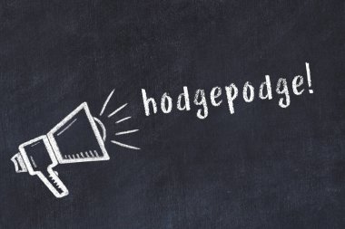Hoparlörün tebeşir çizimi ve siyah masanın üzerine el yazısıyla yazılmış harf karışımı.