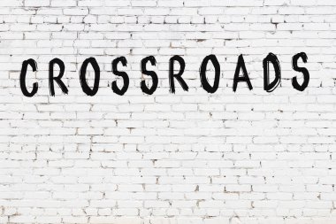 Üzerinde siyah boya bulunan beyaz tuğlalı bir duvar.