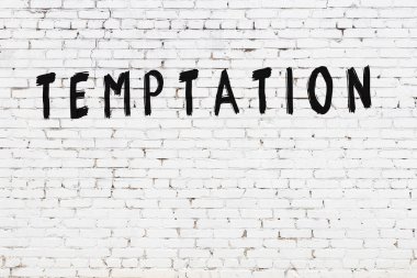 Beyaz tuğla duvara siyah boya ile yazılmış bir yazıt..