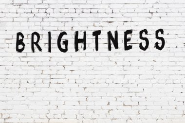 Siyah boyayla el yazısıyla yazılmış beyaz tuğla duvar.