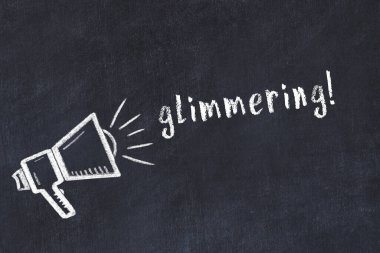 Hoparlörlerin tebeşir çizimi ve siyah masanın üzerinde parıldayan el yazısı.