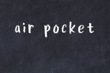 Tebeşir el yazısıyla yazılmış hava cebi siyah masanın üzerinde.