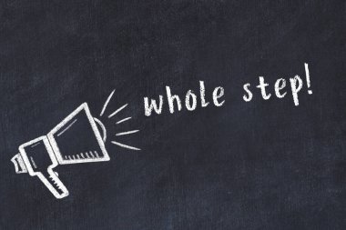 Hoparlörün tebeşir çizimi ve el yazısıyla yazılmış yazı. Tüm basamak siyah masanın üzerine.