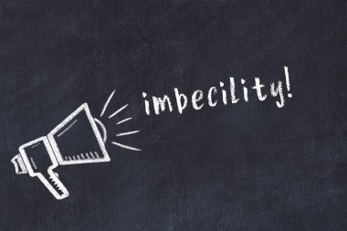 Hoparlörün tebeşir çizimi ve siyah masaya elle yazılmış embesillik.