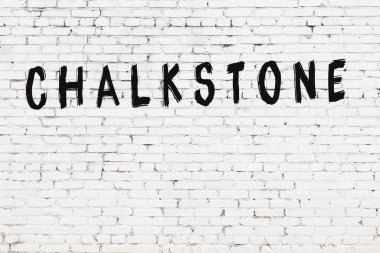 Yazılı beyaz tuğla duvar, el yazısıyla siyah boya.