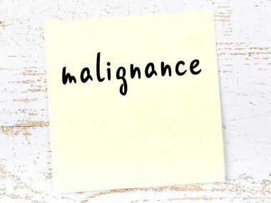 Kötülüğü hatırlatma kavramı. Tahta duvarda üzerinde yazı olan sarı yapışkan kağıt.