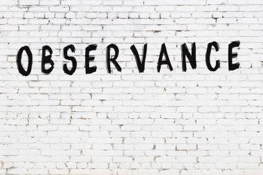 Üzerinde siyah boya bulunan beyaz tuğla bir duvar.