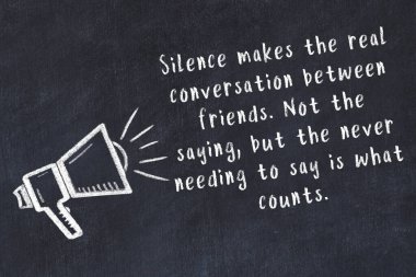 Bir hoparlörün tebeşir çizimi ve siyah karatahtaya el yazısıyla yazılmış alıntılar