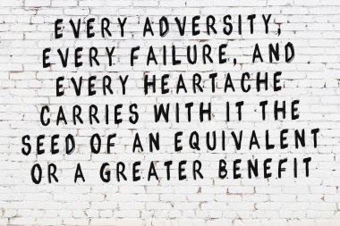 Beyaz tuğla duvar ve bilgece alıntıların yazılı olduğu siyah yazı.