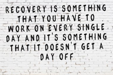 Üzerinde mantıklı alıntıların yazılı olduğu siyah boyanmış beyaz tuğla duvar.