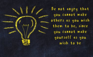 Bilgece bir alıntı ve siyah karatahtaya bir ampul çizimi