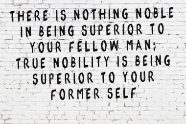 Üzerinde mantıklı alıntıların yazılı olduğu siyah boyanmış beyaz tuğla duvar.